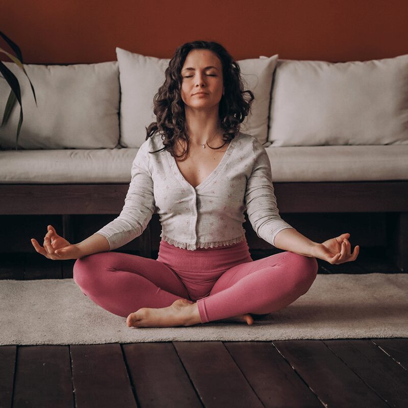 Femme en pleine méditation, incarnant une routine matinale apaisante et équilibrée, promue par L'Appart Fitness.