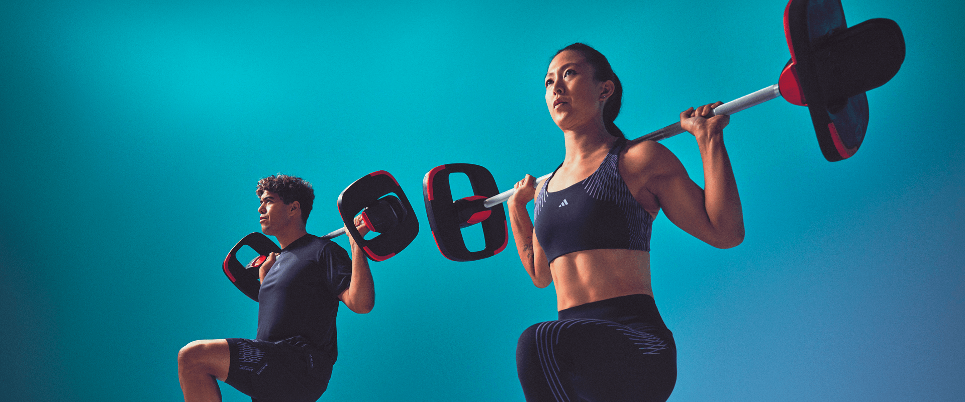 Participants réalisant des fentes avec barre lors des cours de Strength Endurance à L'Appart Fitness.