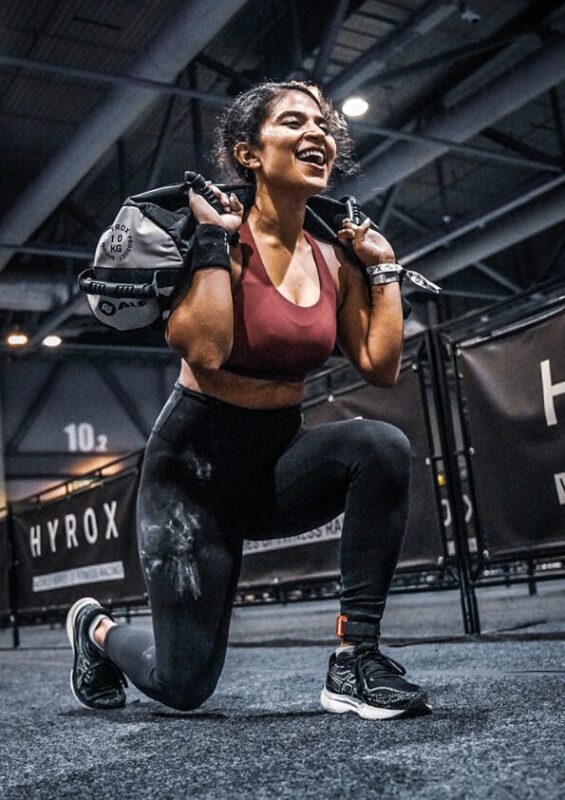 Entraînement Hyrox chez L'Appart Fitness Villeurbanne – Exercice de sandbag lunges pour développer force et endurance.